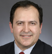 Jon Koznick, white man with dark brown hair wearing a suit and tie